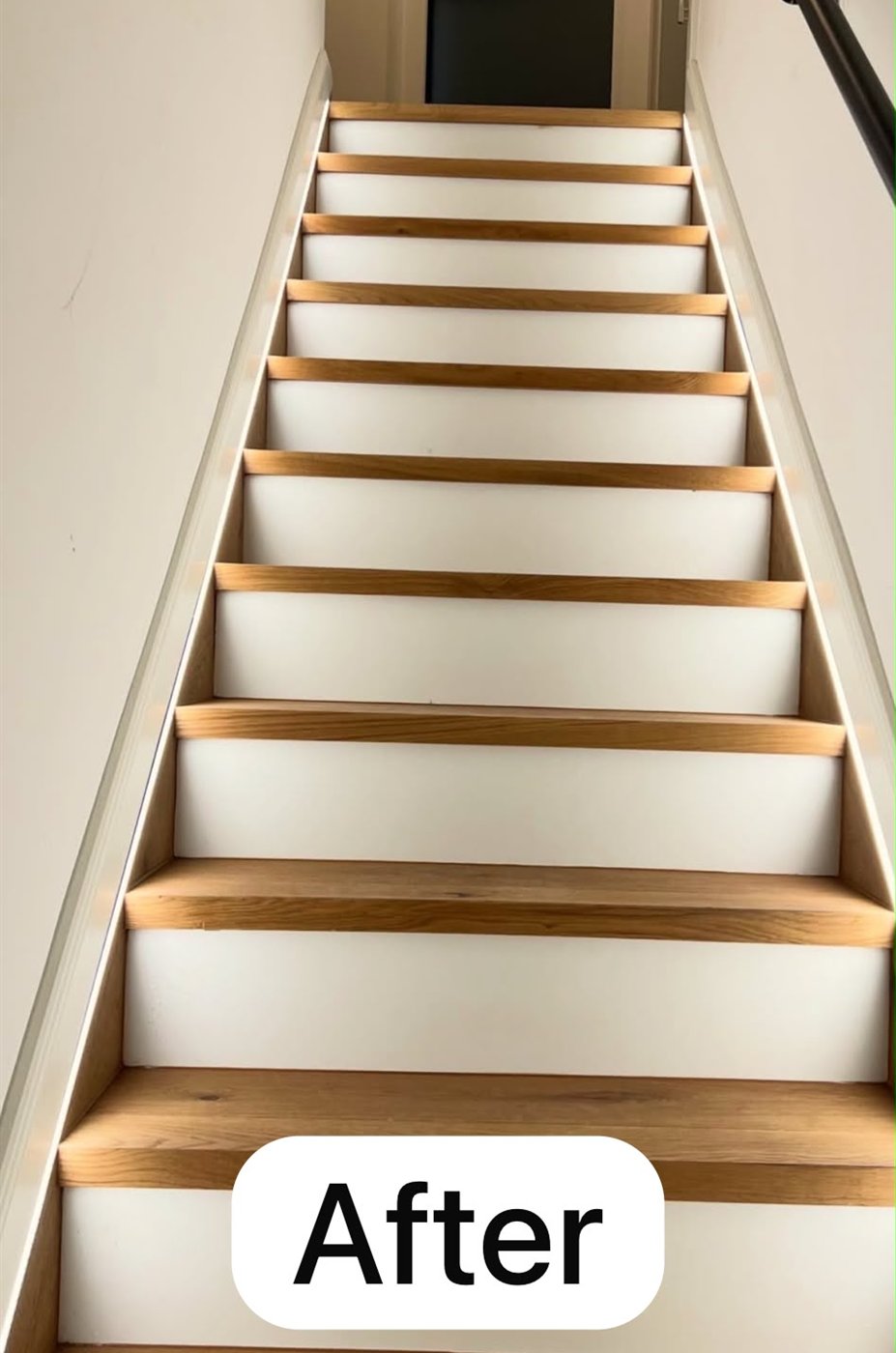 The same staircase after — oak treads with clean white painted risers