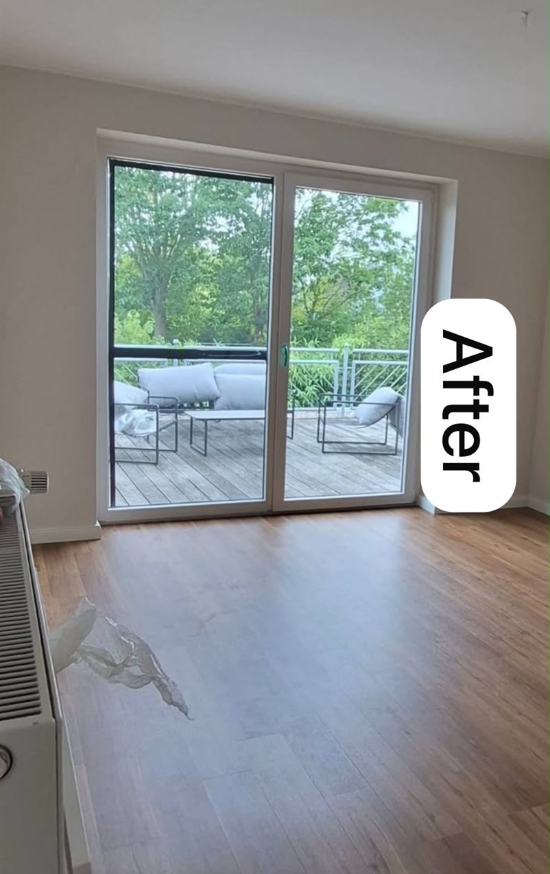 The same living room after — painted walls and ceiling with new flooring